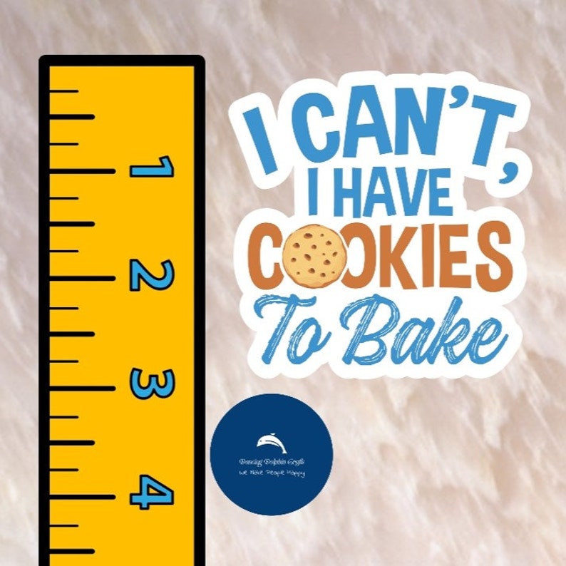 Może przedstawiać: Biała naklejka z niebieskim i brązowym tekstem, kt&oacute;ry brzmi "I CAN'T, I HAVE COOKIES TO BAKE". Brązowe ciasteczko z czekoladowymi kawałkami znajduje się w środku tekstu. Po lewej stronie obrazu znajduje się ż&oacute;łta linijka z niebieskimi liczbami. Niebieskie koło z białym delfinem i tekstem, kt&oacute;ry brzmi "Pancing Dolphin Crafts we make seashells happy", znajduje się na dole obrazu.