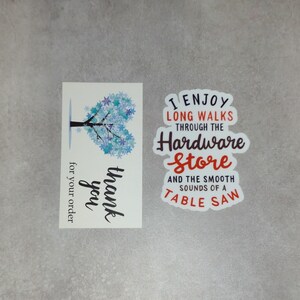 May include: A thank you card with a blue snowflake tree design and the text "thank you" and "for your order". A sticker with the text "I enjoy long walks through the hardware store and the smooth sounds of a table saw".
