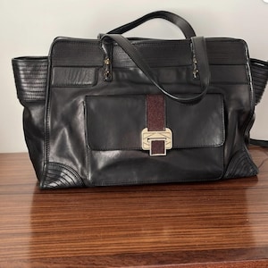 Bolso tipo cartera de piel negra de Rebecca Minkoff con estampado de raya