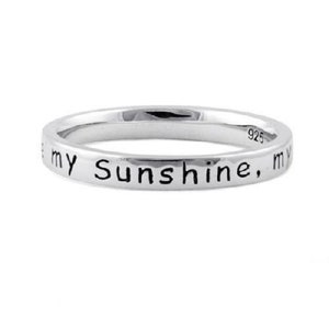 May include: A silver band ring with the inscription "You are my sunshine, my only sunshine" on the outside of the band.