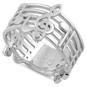 May include: Sterling silver ring featuring a treble clef and musical notes. The ring is made of a thick band with a textured surface. The ring is marked with the number "925" on the inside.