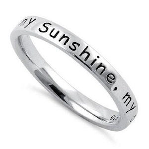 May include: A silver band ring with the inscription "my sunshine, my"