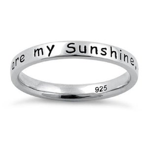May include: A silver band ring with the inscription "You are my sunshine" on the outside of the band. The inside of the band is stamped with "925".