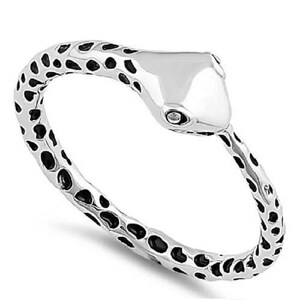 May include: A silver-colored ring in the shape of a snake. The snake's body has a textured pattern of black spots on a silver background. The snake's head is smooth and polished, with a small eye detail.