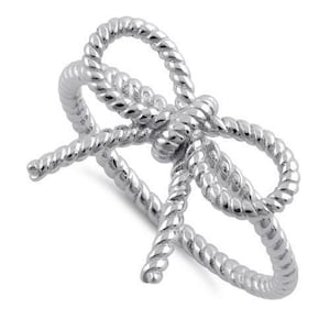 May include: Silver ring with a rope design in the shape of a bow.
