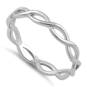 May include: A silver-colored ring with an interwoven design. The ring features a continuous pattern of intertwined loops, creating a braided or woven appearance. The ring is made of a shiny, reflective metal, and the size is not specified.