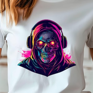 Puede incluir: Camiseta blanca con un gráfico colorido de una calavera con auriculares y una capucha. La calavera tiene ojos rojos brillantes y está rodeada de salpicaduras rosas y moradas. El diseño está centrado en la parte delantera de la camiseta.