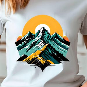 May include: White t-shirt featuring a mountain range graphic with a yellow sun in the background. The mountain design incorporates shades of teal, yellow, and black. The shirt is a classic crew neck style.