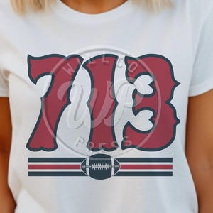 Puede incluir: Camiseta blanca con un diseño rojo y azul que presenta el número "713" y un gráfico de fútbol. El texto "Wellco Press" está impreso en un círculo alrededor del número.