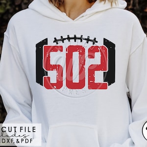 May include: A white hoodie with a red and black football design featuring the number "502". The design has a distressed look and is centred on the front of the hoodie.