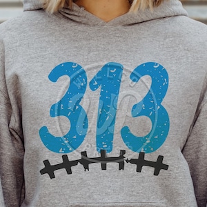 Puede incluir: Sudadera gris con un número "313" azul desgastado y costuras negras debajo.