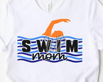 May include: White t-shirt with a blue and white striped wave design and the text "Swim Mom" in black. A silhouette of a swimmer in orange is swimming in the waves.