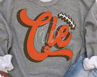 Puede incluir: Una sudadera gris con un gráfico naranja y marrón desgastado que dice "Life" con un diseño de puntada de fútbol.