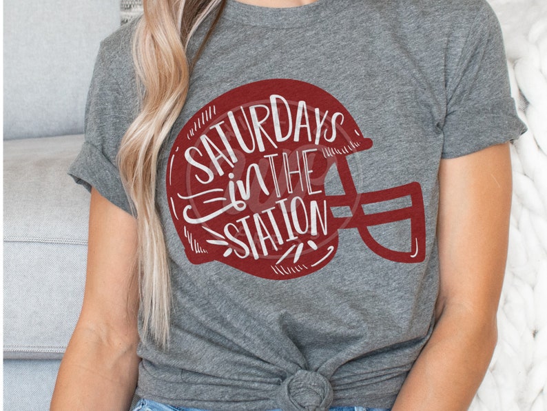 May include: Gray t-shirt with a red football helmet graphic and the text "Saturdays in the Station" in white.