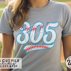 Puede incluir: Una camiseta gris claro con el número "305" en blanco con un contorno azul y costuras de béisbol rojas. La camiseta incluye el texto "SVG CUT FILE includes PNG, DXF, & PDF" y un logotipo que dice "WILLCO WP PRESS".