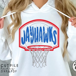 May include: A white hoodie with a red, white, and blue basketball hoop design featuring the word "JAYHAWKS" in blue lettering. The design includes a gray basketball net.