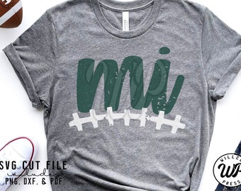 May include: A gray t-shirt with a distressed green "MI" design and white stitching. The design is reminiscent of a football field.