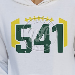 Puede incluir: Sudadera blanca con un diseño gráfico verde y amarillo con los números "541" y el texto "Express" debajo. El gráfico está estilizado para parecerse a una camiseta de fútbol.