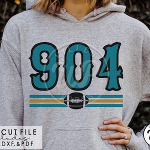 May include: A gray hoodie with a teal and gold design featuring the number "904" and a football. The design includes two gold stripes and a black football.