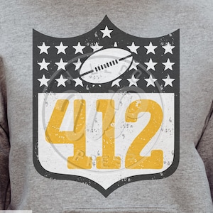 May include: A gray sweatshirt with a black and white shield design featuring a football and the number 412 in yellow. The shield has a distressed look and is surrounded by white stars.