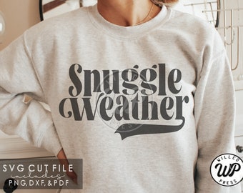 May include: A gray sweatshirt with the text "Snuggle Weather" in black lettering. The text is in a retro font style with a baseball-style tail.