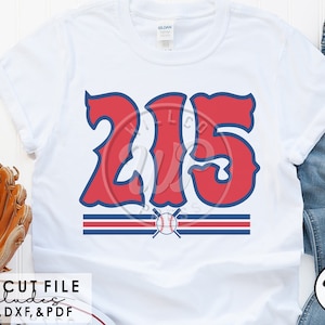 May include: A white t-shirt with a red and blue baseball themed design featuring the number "215" in a stylized font. The design includes a baseball and crossed bats.