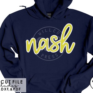 以下が含まれることがあります： 前面に「Willco Nash Press」と書かれた黄色の円形ロゴが付いたネイビーブルーのパーカーです。