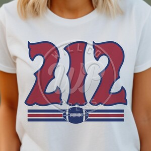 Puede incluir: Camiseta blanca con un diseño rojo y azul que presenta el número "212" en una fuente estilizada. Un gráfico de fútbol está debajo del número.