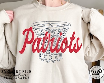 May include: A white sweatshirt with a red and blue design. The design features a basketball hoop with the word "Patriots" written in red cursive.