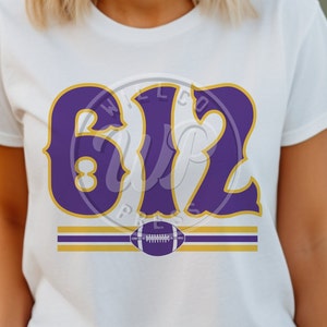 Könnte beinhalten: Weißes T-Shirt mit einem violetten und goldenen "612"-Design und einer Fußballgrafik.