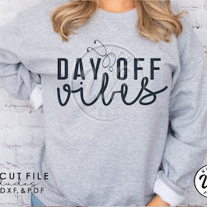 May include: A gray sweatshirt with the text "DAY OFF vibes" in black lettering. A stethoscope is incorporated into the design above the text. The text "SVG CUT FILE includes PNG, DXF, & PDF" is at the bottom of the image.