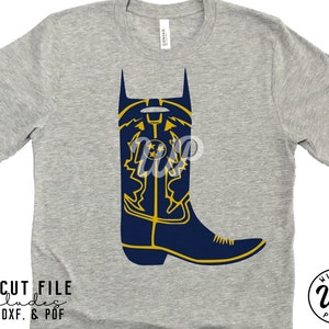 May include: A gray t-shirt featuring a navy blue cowboy boot design with yellow accents. The boot has a decorative pattern and three stars. The text "SVG CUT FILE includes PNG. DXF. & PDF" is at the bottom.