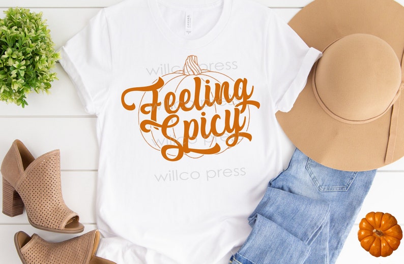 May include: White t-shirt with an orange pumpkin graphic and the text "Feeling Spicy".