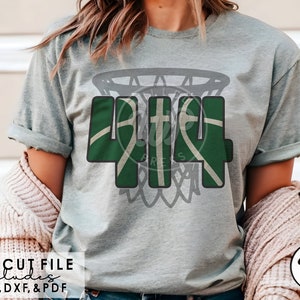 May include: Green and white basketball themed design with the number 414 inside a basketball hoop. The design is on a grey t-shirt.