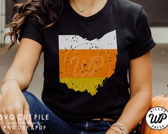 May include: A black t-shirt with a white, orange, and yellow graphic of the state of Ohio shaped like a candy corn. The graphic has a distressed look. The text "WP PRESS" is visible on the graphic.