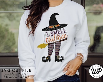 May include: A white sweatshirt with a black witch's hat, legs, and broom. The text "I SMELL children" is printed on the shirt.