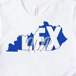 May include: A white t-shirt with a blue outline of the state of Kentucky and the word "LEX" in white letters inside the outline.