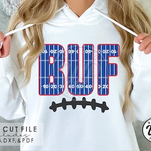 May include: A white hoodie with a blue and red football field design that spells out "BUF" with a black football stitch design underneath.