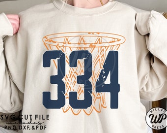 May include: A white sweatshirt with a distressed navy blue number "334" and an orange basketball hoop graphic. The text "SVG CUT FILE Includes PNG, DXF, & PDF" is at the bottom of the image.