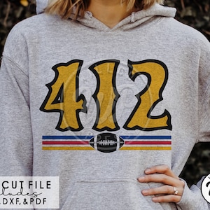 May include: A gray hoodie with a yellow and black design featuring the number "412" and a football. The design also includes three horizontal stripes in red, blue, and yellow.