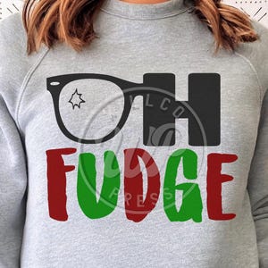 May include: Gray sweatshirt with the text "Oh Fudge" in black letters and a pair of black glasses with a star in the lens. The word "Fudge" is in red and green letters.