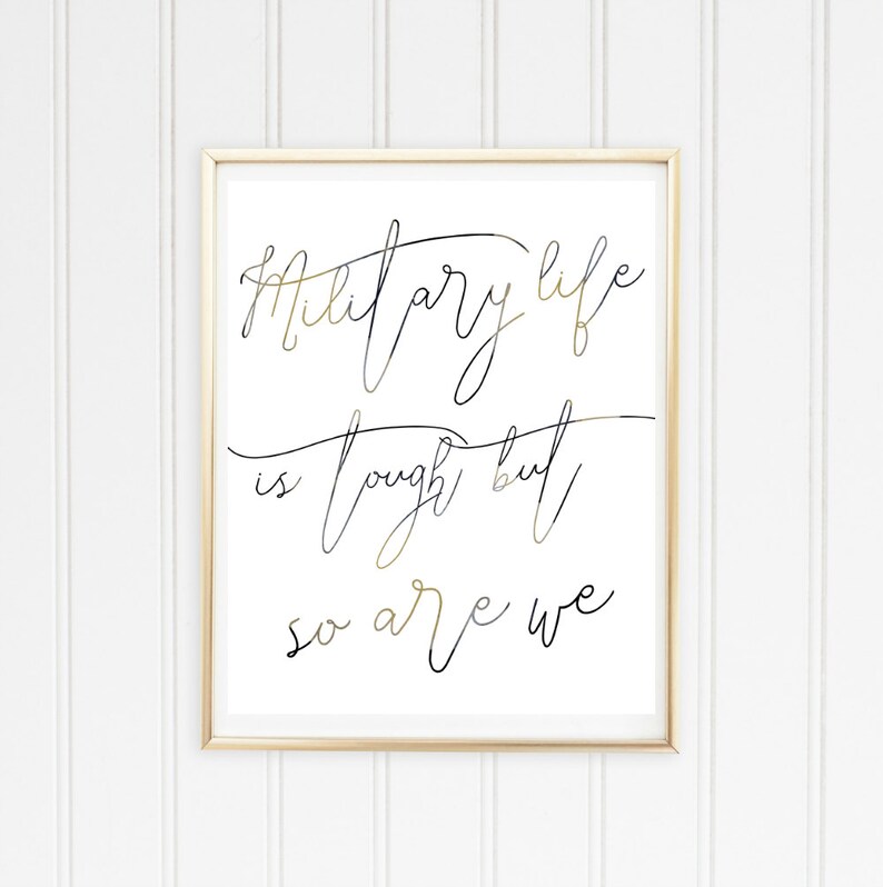May include: A framed print with a gold frame and a white background. The print features black and gold calligraphy that reads "Military life is tough but so are we."