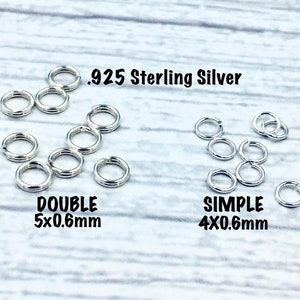May include: Two sets of silver jump rings on a wooden surface. The set on the left is labelled "DOUBLE 5x0.6mm" and the set on the right is labelled "SIMPLE 4x0.6mm". Both sets are made of .925 Sterling Silver.