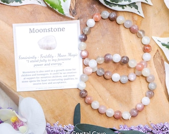 May include: A moonstone bracelet with a card that reads "Moonstone: Femininity, Fertility, Moon Magic. "I stand fully in my feminine power and energy." Moonstone is also used as a growth stone for children and teenagers. It could be an emotional support for sensitive children, and moonstone opens the heart to nurturing qualities, to receive love and acceptance."