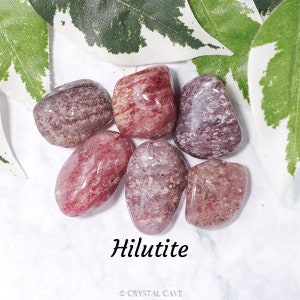 May include: A collection of six Hilutite tumbled stones. The stones are a mix of pink, red, and white with a striated pattern.