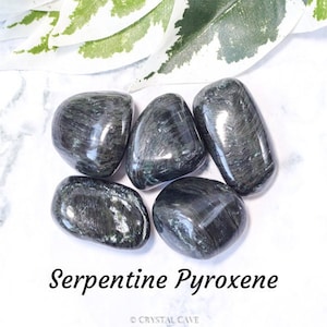 May include: Five smooth, dark green and black serpentine pyroxene tumbled stones. The stones have a shiny, polished finish. Serpentine Pyroxene.