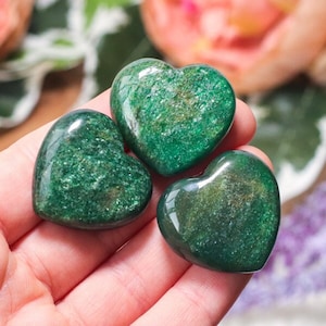 May include: Three green aventurine heart shaped crystal stones. The stones are polished and have a sparkly, glittery finish.