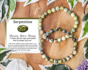 Pode incluir: Um bracelete de pedra serpentina verde com um cartão que diz "Serpentina Limpeza - Natureza - Mudanças "Eu me livrei dos velhos caminhos e crenças que não me servem mais." A serpente, que está perto desta pedra, é venerada como um símbolo de boa saúde e é simbolizada nas instituições médicas. A razão para isso porque a serpente muda de pele e sai de sua velha pele."