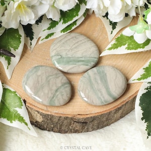 May include: Three smooth, polished green and gray serpentine stones. The stones are oval shaped and have a natural, swirling pattern.