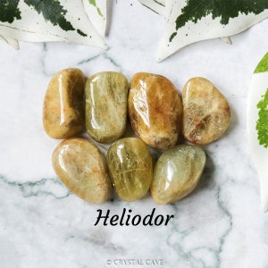 May include: A collection of six smooth, polished, green and yellow Helidor gemstones. The stones are tumbled and have a natural, earthy look.